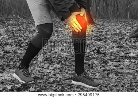 A Man In Training Clothes Got A Knee Injury While Jogging In Outdoor Workout. Concept Of Sports Inju