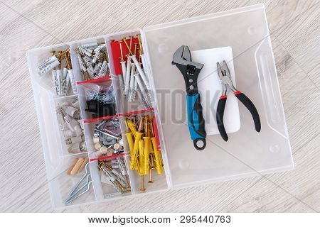 Box With Special Tools, Parts, Pliers And Adjustable Wrench, Closeup. Tools On Light Wooden Backgrou