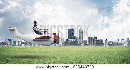 Happy Aviator Driving Small Propeller Plane. Modern Business Center With High Skyscrapers On Backgro