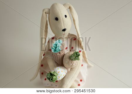 Cute Textile Rabbit Dressed In A Polka Dot Dress With An Armful Of Textile Carrots