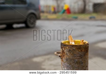 Cigarette Butts Are Stored In A Pipe Of A Column Of A Protection For The Parking Which Is About The 