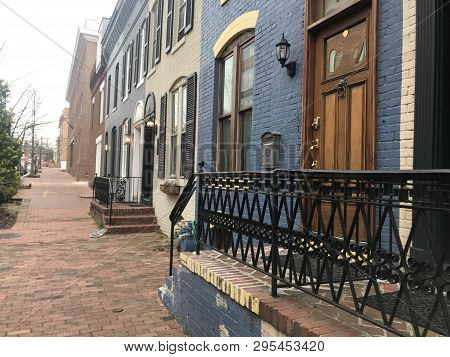 Painted Brownstone Houses Line A Brick Street In Georgetown, Washington, Dc