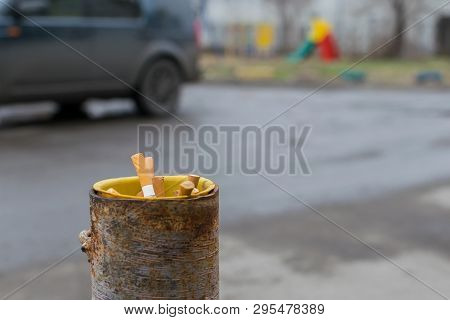 Cigarette Butts Are Stored In A Pipe Of A Column Protection For The Parking Which Is About The Road 