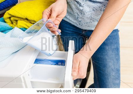 Washing Powder Detergent And Measuring Cup Pouring Into Machine. Household Duties, Clothes Laundry O