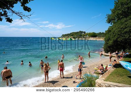 Porec, Croatia - July 17, 2018: Tourists And Holidaymakers On The Beach Of The Adriatic Sea Near Por