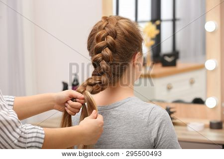 Professional Coiffeuse Braiding Client's Hair In Salon