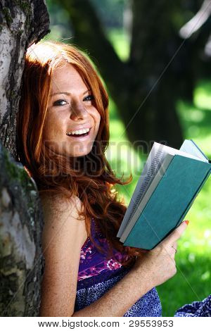 bella ragazza legge il libro nel parco