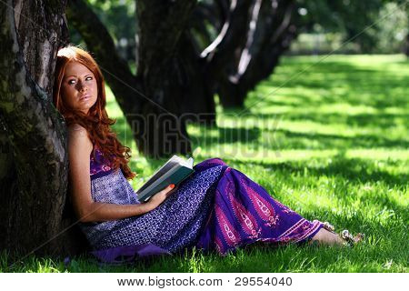 bella ragazza legge il libro nel parco
