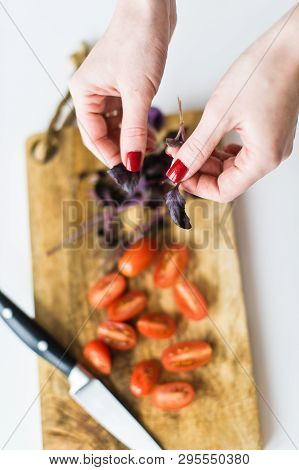 The Chef Tears Off The Leaves Of Basalica. Top View, White Background