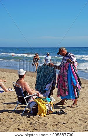 Marbella, Spain - September 12, 2008 - Beach Trader Showing His Goods To A Tourist On Playa De La Vi