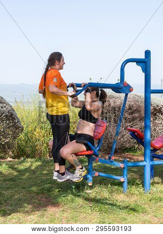 Safed, Israel, April 13, 2019 : Two Athletes Perform Exercises On Outdoor Public Exercise Machines I