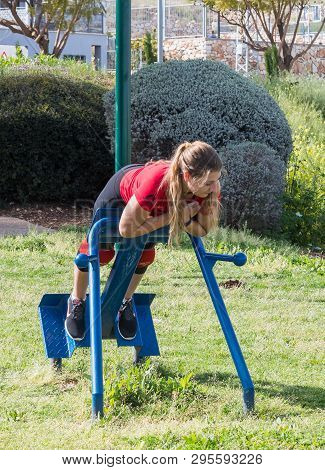 Safed, Israel, April 13, 2019 : Girl Athlete Performs An Exercise To Strengthen The Back On A Street