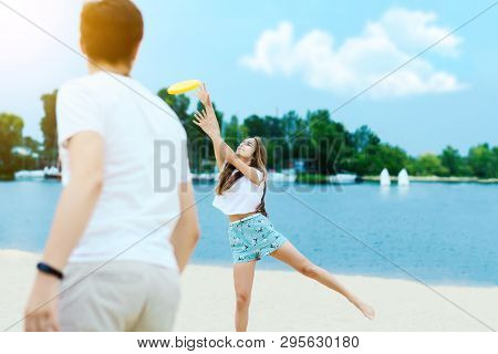 Young Smiling Woman In Light Clothes Is Holding White Racket And Ball In Her Hands. Cheerful Female 