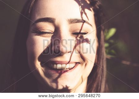 Young Woman Closeup Face Portrait In The Woods With Branch Of A Tree As A Gobo. Natural Beauty, Ecol