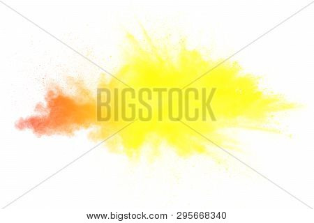 Abstract Yellow Orange Powder Explosion On White Background. Freeze Motion Of Yellow Orange Dust Par