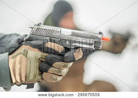 Close-up Detail View Of Shooter Hands Holding Gun With Safety Stick. Shooting Range