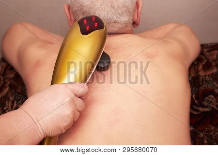 Old Gray-haired Man Patient Receive Electrostatic Therapy Procedure On His Back. Electrostimulation 