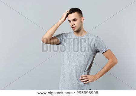 Portrait Of Preoccupied Young Man In Casual Clothes Looking Down And Putting Hand On Head Isolated O