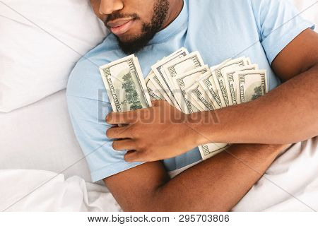 Greedy African American Guy Sleeping And Keeping Lots Of Currency Notes In Bed, Top View