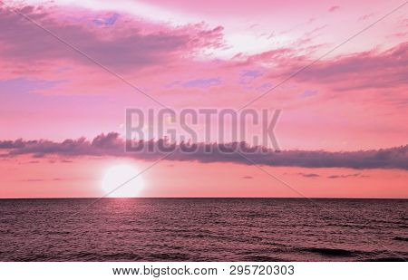 Landscape With Sun At Sunset And Pink Clouds Over The Ocean