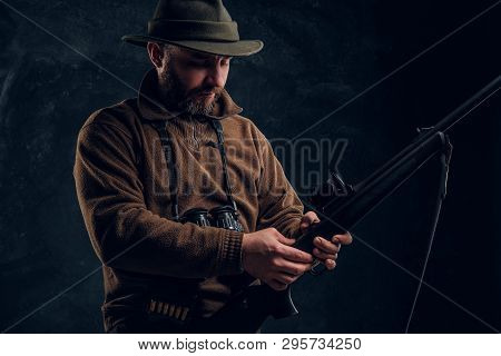 Opening Of The Spring Hunting Season. Hunter Ready To Hunt And Charging A Hunting Rifle. Studio Phot