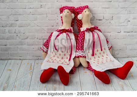 Tilda Doll, Soft Toy With A Heart, Sitting On A Wooden Background. Handcraft Concept. There Is A Pla