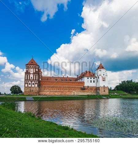 Medieval Castle In Mir, Belarus. Panoramic View Of Old Castle And Its Moat Under Cloudy Sky In Summe