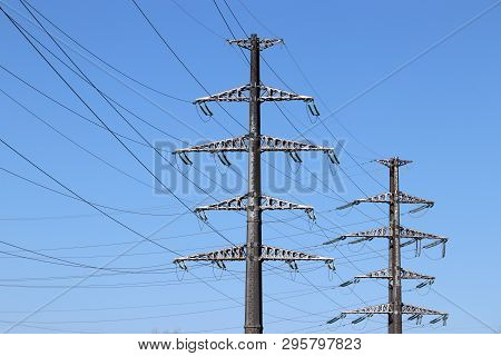 High Voltage Power Line Supports With Electrical Wires Isolated On Clear Blue Sky Background. Electr