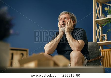 Inability To Tolerate. Old Bearded Man With Alzheimer Desease Sitting On The Chair And Suffering Fro