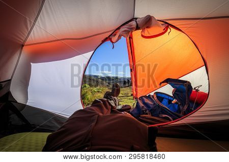 Someone Lying In A Tent And Enjoying The Sunlight Falling Onto His Legs In Iceland.