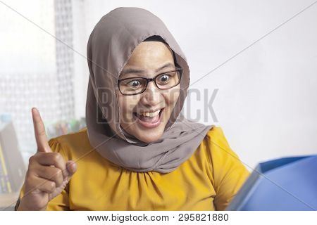 Portrait Of Asian Muslim Businesswoman Working On Laptop At The Office,amiling And Thinking Gesture,