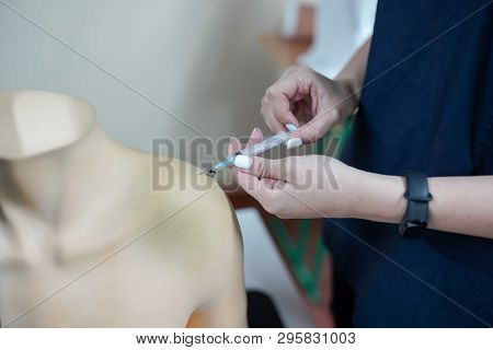 Nursing Student Practicing Blood Taking On Mannequin Hand Under Instructor Supervision . Medical Bac