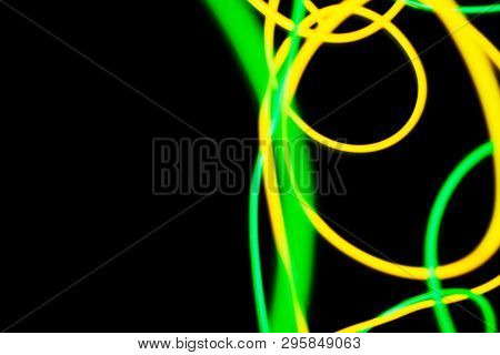 Yellow And Green Neon Lines Abstraction. Neon Lights. Isolated On Black Background. Modern Art.