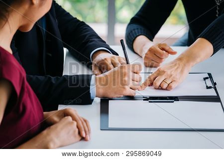 Close-up Of Married Couple Signing Papers Alongside With Other Witness Or Agent - Can Be Divorce, La