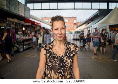 Portrait Of A Smiling Woman At The Jean-talon Farmers Market. The Joyful Visitors Of The Market Are 