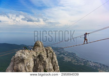 Mishor, Yalta, Crimea, Russia - September 14, 2018: Tourists Walk On A Rope Bridge Stretched Between
