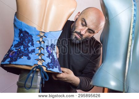 Close Up Photo Of Fashion Designer Working On His New Creation, Beautiful Blue Corset. Tailor Dummy 