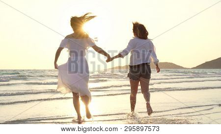Young Asian Lesbian Couple Running On Beach. Beautiful Women Friends Happy Relax Having Fun On Beach