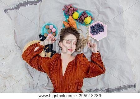 Style Adult Woman Lying Down On A Litter Near Macrons And Fruits On A Sand, Beach. Above Ivew
