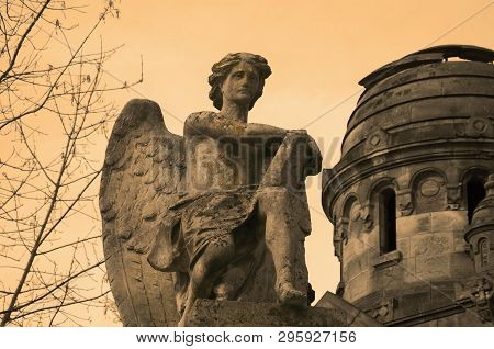 Angel Of Death With A Book Of Life Against The Background Of The Ruins Of An Old Church. Special Eff