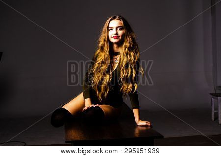 Beautiful Dancer. Girl Model. The Girl Sits In A Hat And Sits On A Table. Girl In A Beautiful Underw
