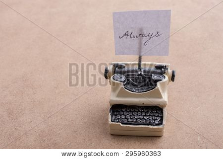 Retro Syled Tiny Typewriter Model On A Brown Background