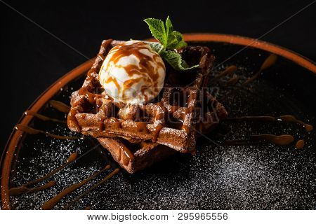 Plate of belgian waffles with chocolate sauce and ice cream 