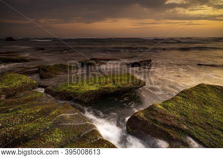 Calm Ocean Long Exposure. Stones Covered By Geen Moss In Mysterious Mist Of The Sea Waves. Concept O