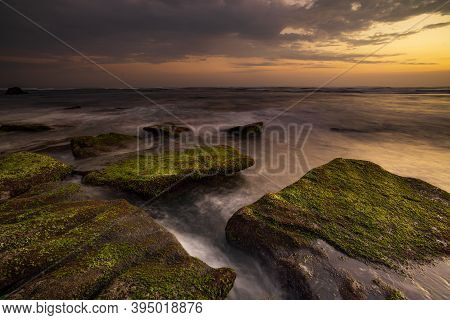 Calm Ocean Long Exposure. Stones Covered By Geen Moss In Mysterious Mist Of The Sea Waves. Concept O