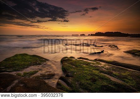 Calm Ocean Long Exposure. Stones Covered By Geen Moss In Mysterious Mist Of The Sea Waves. Concept O