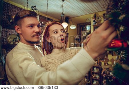 Christmas Tree. Smiling Family, Couple Looking For Home Decoration And Holidays Gifts In Household S