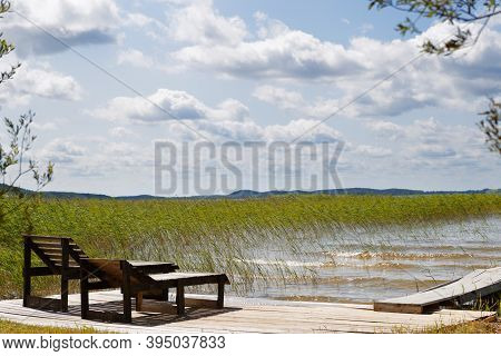 Sun Loungers On The Lake Under A Stormy Sky With Clouds