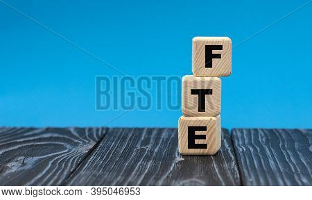 Abbreviation Fte (full Time Equivalent) On Wooden Cubes On A Blue Background. Business Concept