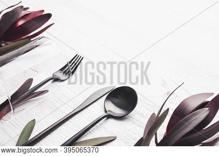 Cutlery And Floral Decor On White Wooden Background, Space For Text. Table Setting Elements